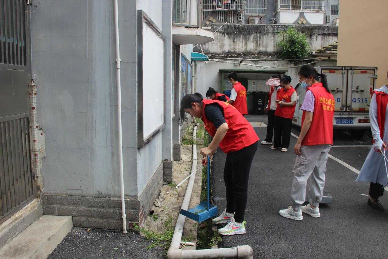 图为志愿者参加社区卫生整治行动.png